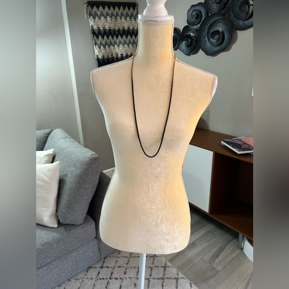 Long gold tone and black necklace.
